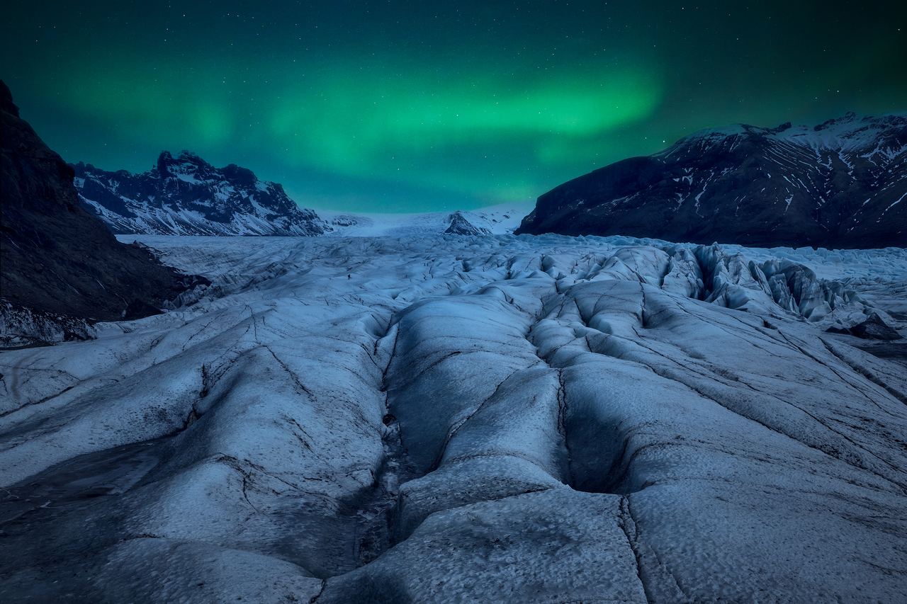 Aurora in the night sky above a glacier tongue and bare ice