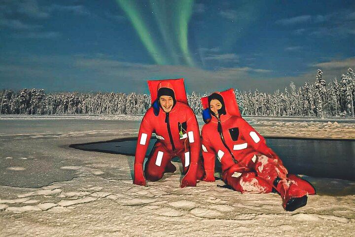 Eine kleine Gruppe von Menschen beobachtet treibendes arktisches Eis unter dem Polarlicht in Rovaniemi (5/12)