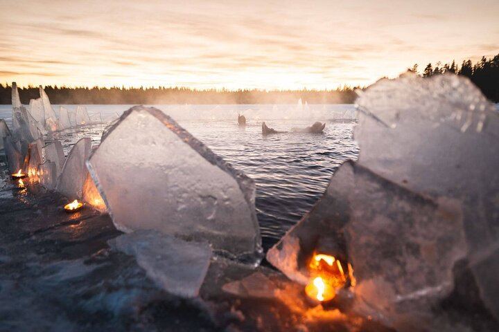 Eine kleine Gruppe von Menschen beobachtet treibendes arktisches Eis unter dem Polarlicht in Rovaniemi (7/12)