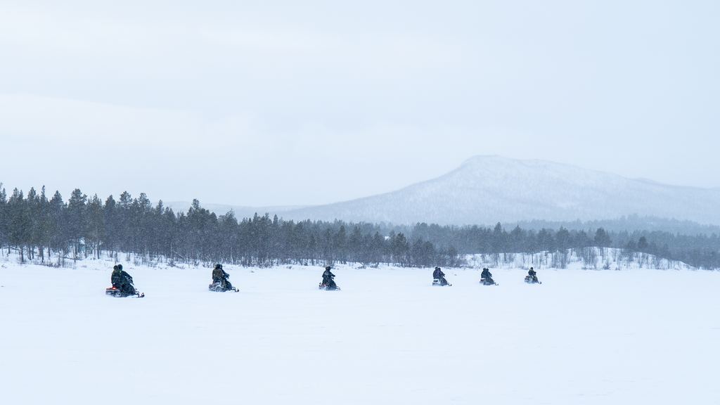 Snowmobiles parked on snow in northern Sweden at dusk